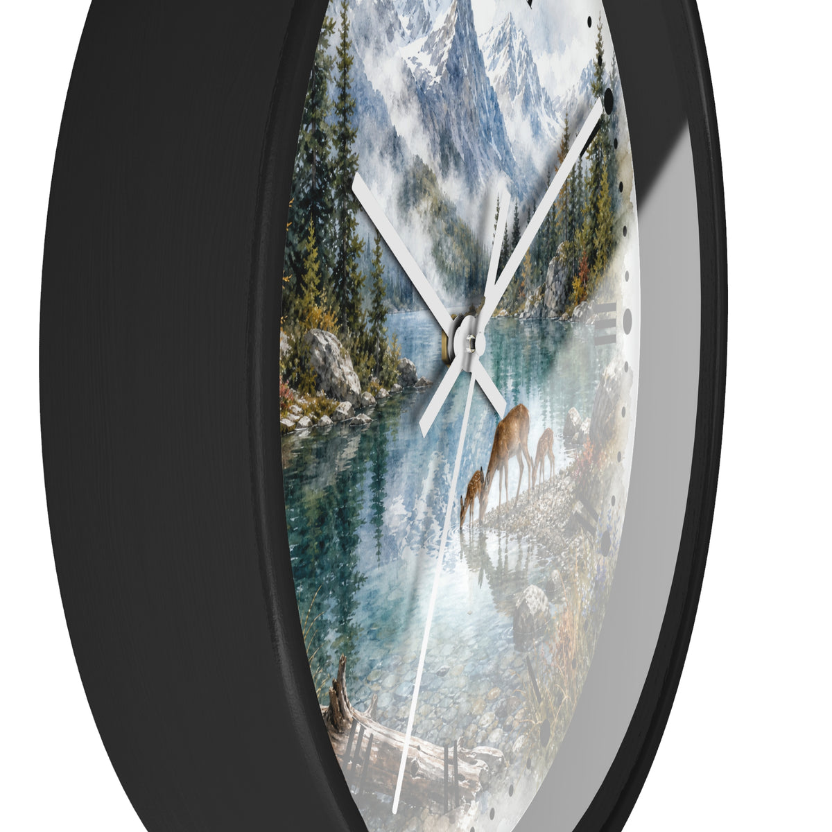 Round wall clock with a black frame and a scenic nature print featuring a mountain lake, evergreen trees, deer, and snowy peaks. The clock has white hands and is shown against a plain white background.