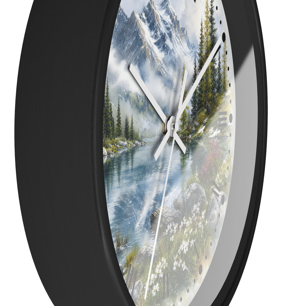 A round wall clock with a black frame and a scenic landscape print featuring a mountain lake, pine trees, and white flowers on the dial.