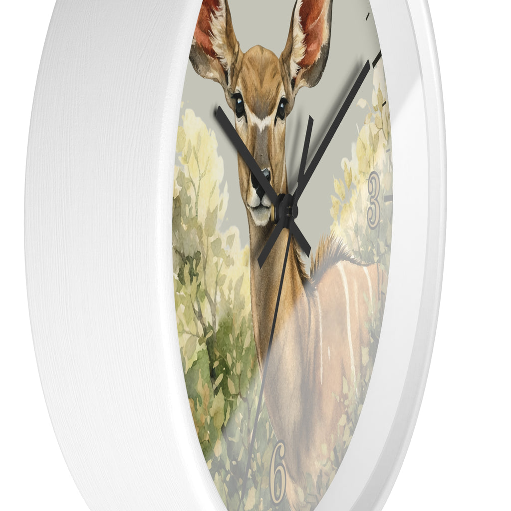 A white round wall clock featuring a printed illustration of a deer in a natural setting on the clock face, with black hands and partial numerals.