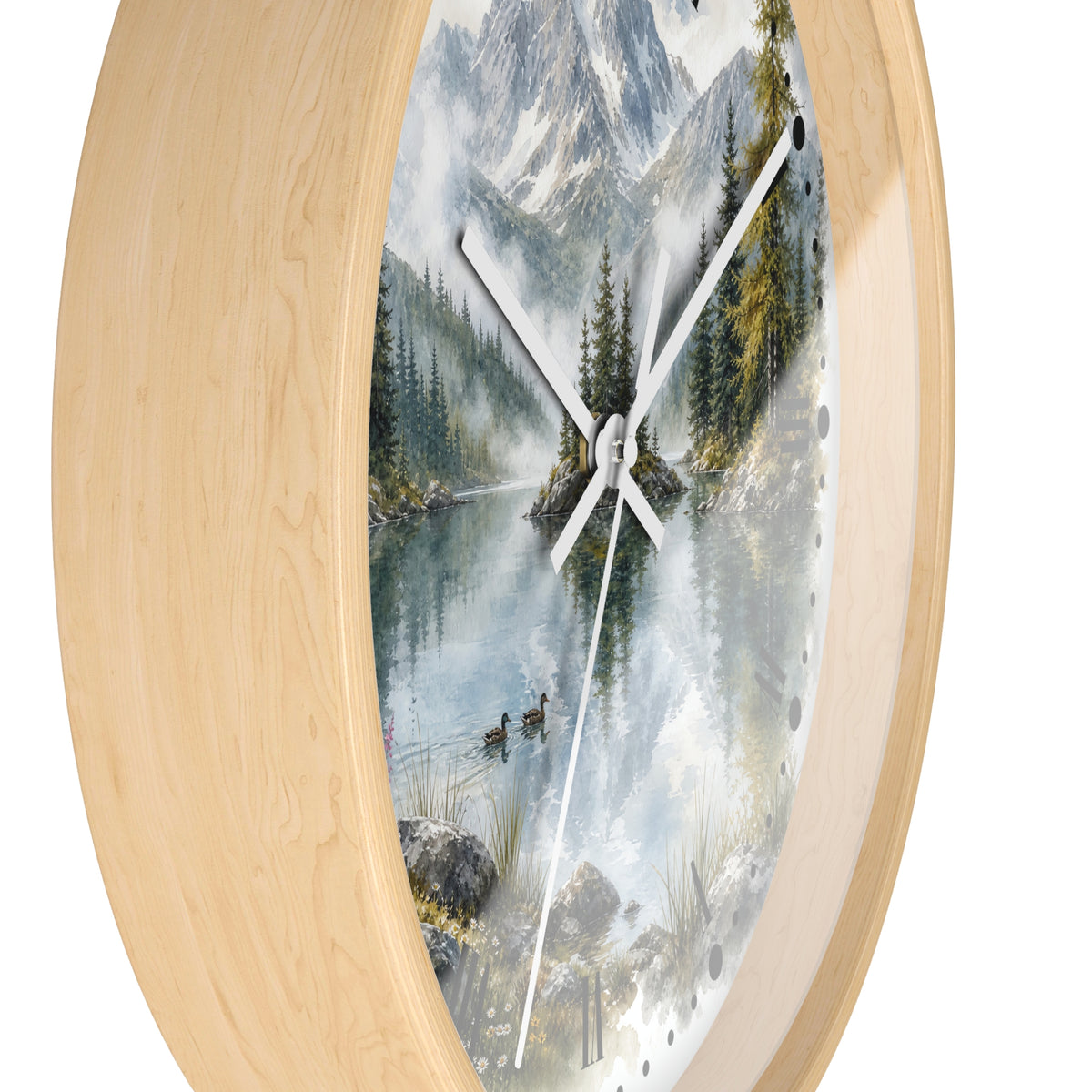 Round wall clock with a light natural wood frame and a scenic print of a mountain lake surrounded by pine trees, shown against a plain white background.