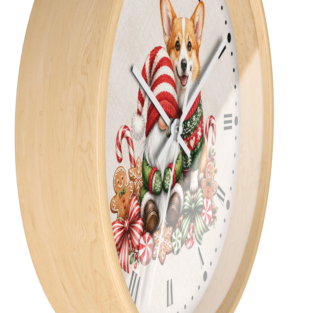 A round wall clock with a light natural wood frame and a white face featuring a festive illustration of a corgi wearing a red-and-white striped Santa hat and green sweater, surrounded by candy canes, gingerbread cookies, and bows.