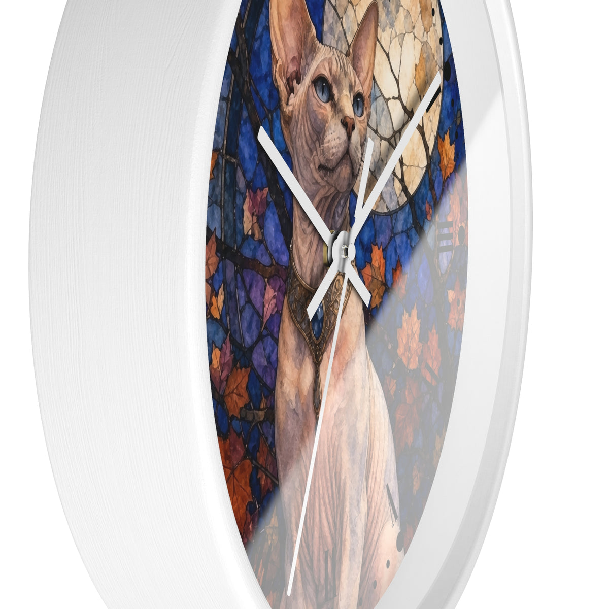 A round white wall clock featuring a printed artwork of a Sphynx cat in front of a stained-glass-style autumn scene with blue, purple, orange, and beige tones.