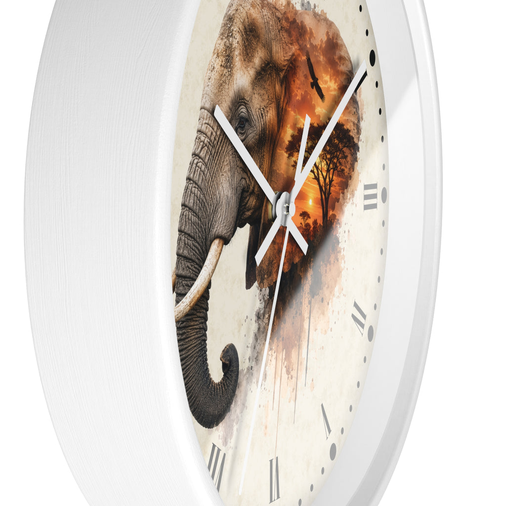 A round wall clock with a white frame and a printed elephant design on the face. The elephant blends into a warm-toned savanna sunset scene with trees, while the clock hands and Roman numerals are visible against a clean white background.