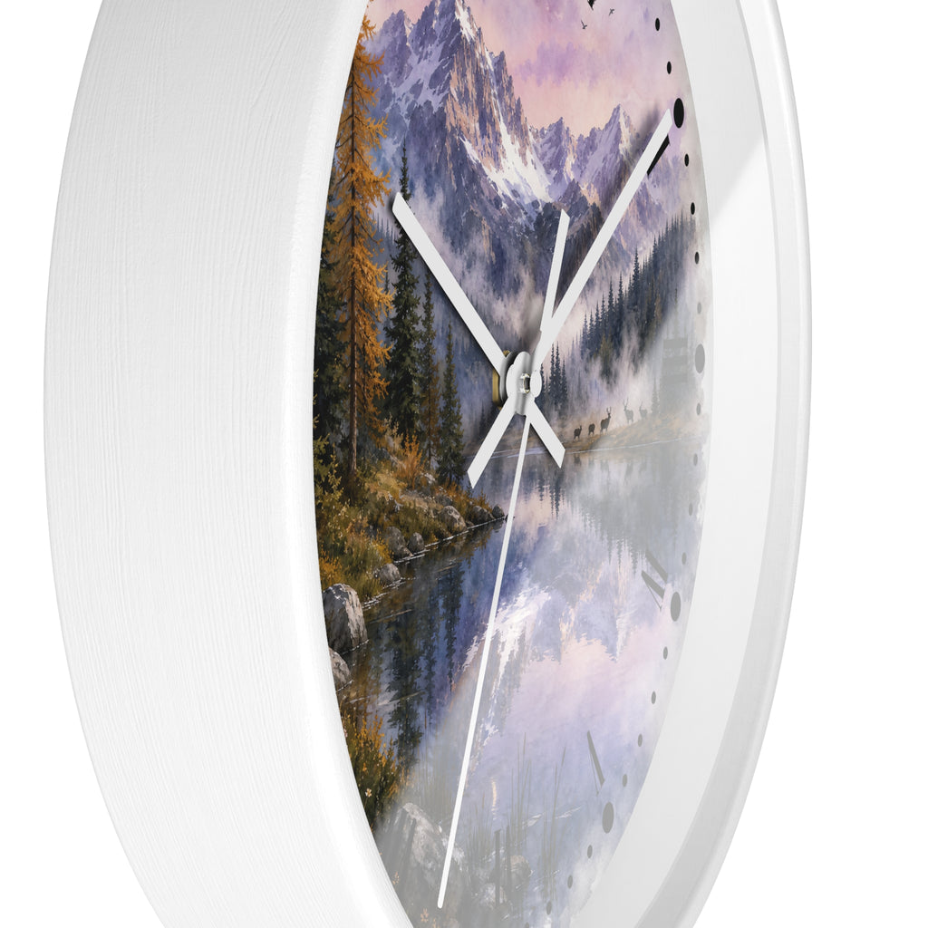 Round wall clock with a white frame and a scenic landscape print featuring mountains, a lake, trees, and a sunset sky, and a herd of deer shown against a white background.