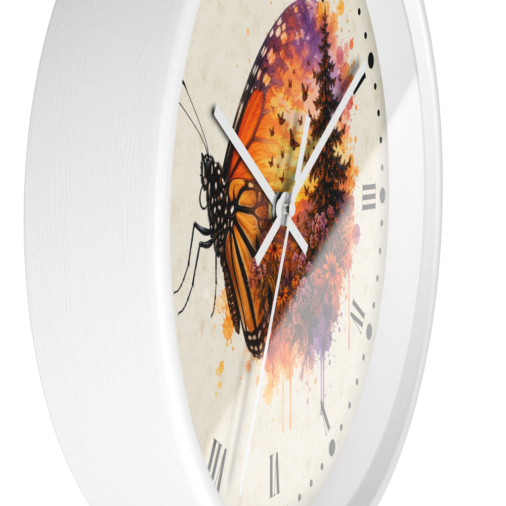 A round wall clock with a white frame and a cream-colored face featuring a large orange and black butterfly over a colorful watercolor background with black Roman numerals.