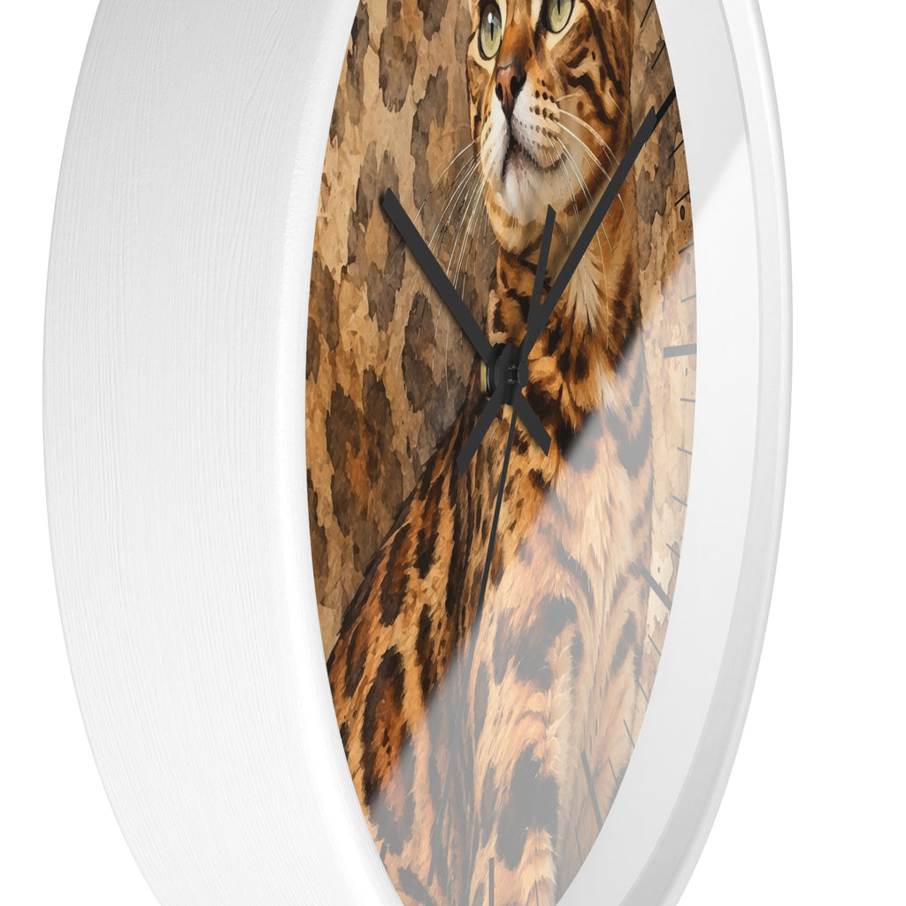 A round wall clock with a white frame and a printed face showing a close-up image of a spotted Bengal cat, against a tan and brown patterned background.