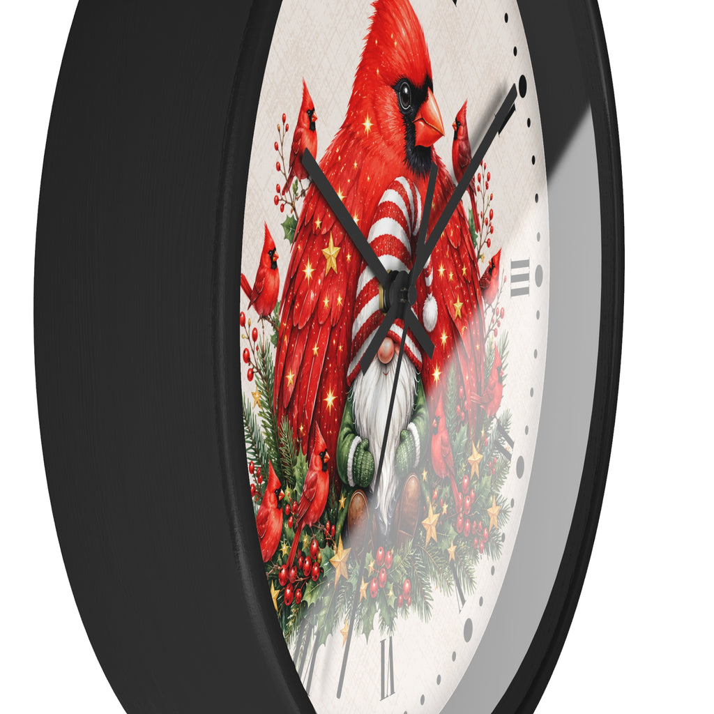 A close-up of a round wall clock with a black frame and a white face featuring a festive illustration of red cardinals, evergreen branches, berries, and holiday lights.