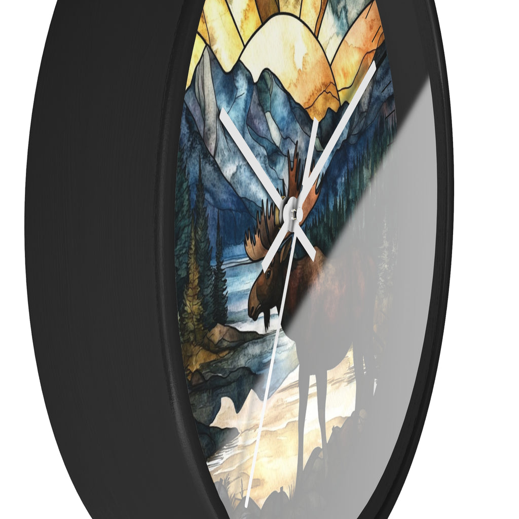 Round wall clock with a black frame and a stained-glass-style nature print featuring a moose, mountains, trees, and a river, shown against a white background.
