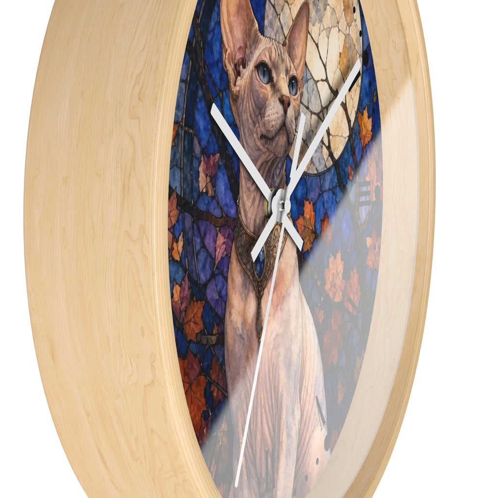 Round wall clock with a light natural wood frame and a printed center artwork of a Sphynx cat in front of a stained-glass-style background with blue, purple, orange, and cream tones.