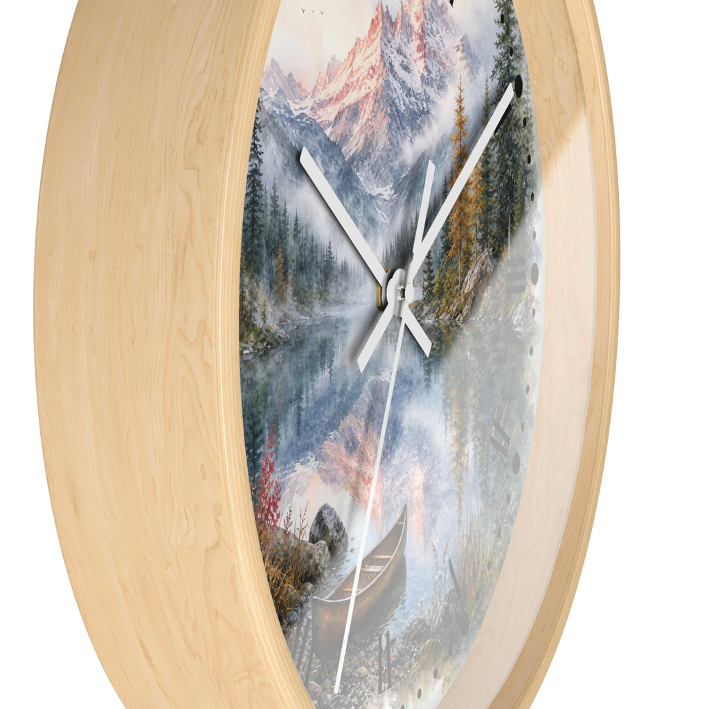 Round wall clock with a light natural wood frame and a scenic landscape print featuring mountains, trees, a lake, and a canoe, shown against a plain white background.