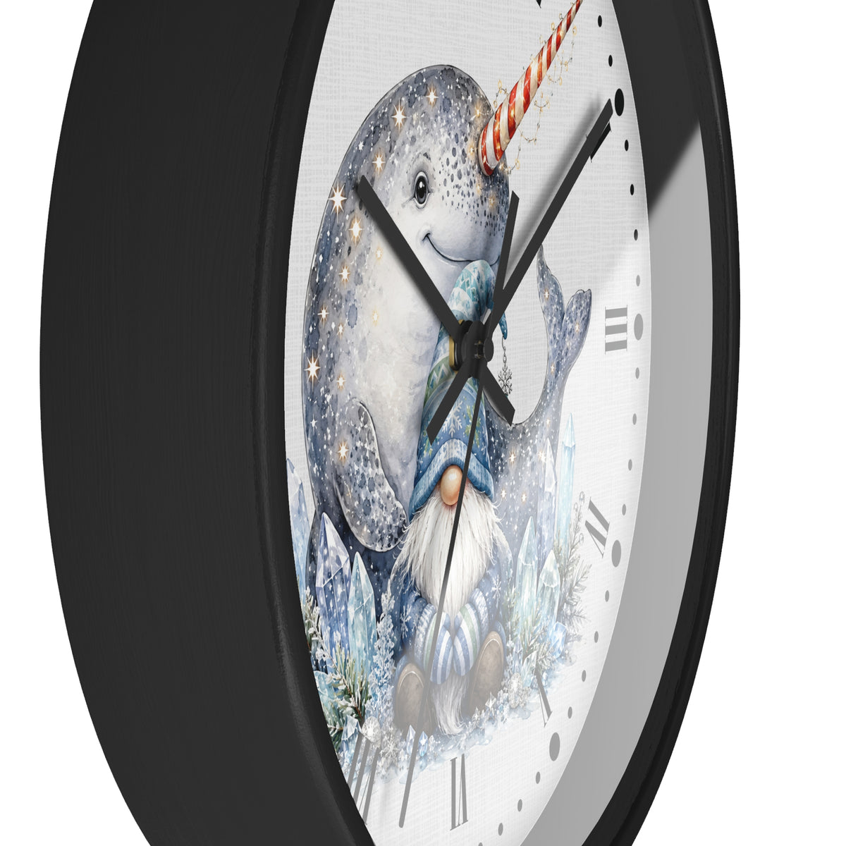 A close-up of a round wall clock with a black frame and a white face featuring an illustrated narwhal and gnome in icy blue tones, photographed against a light gray background.