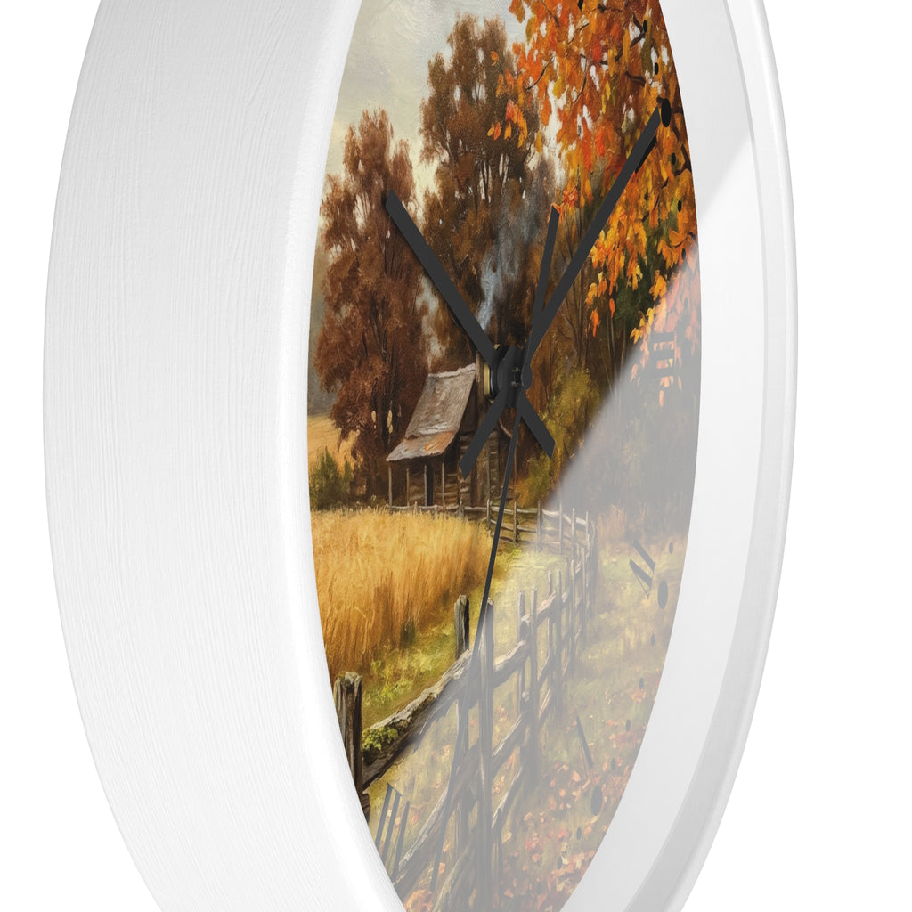 Round wall clock with a white frame and a printed autumn landscape design featuring a rustic cabin, trees with orange and yellow leaves, a fence, and a field, shown against a white background.