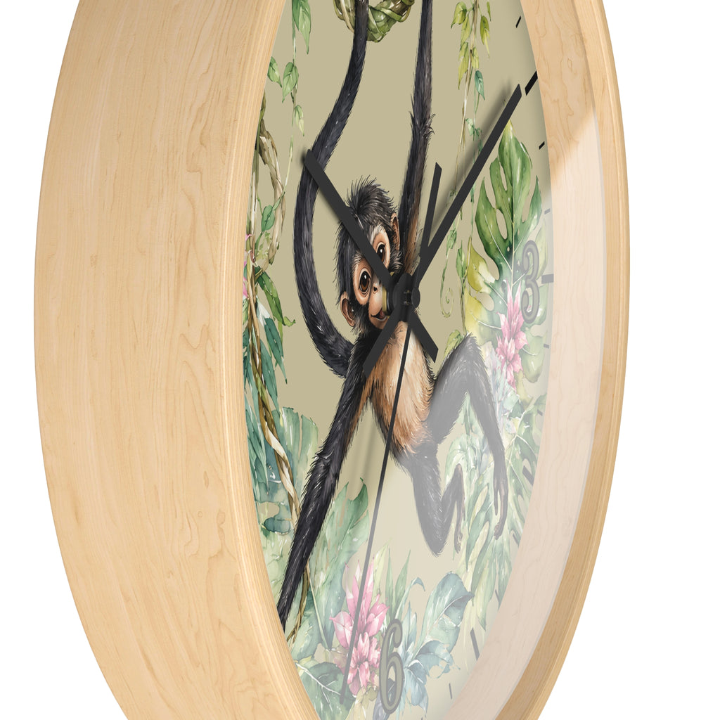Round wall clock with a light natural wood frame and a printed face showing a black-and-tan monkey among green leaves and pink flowers, photographed on a white background.