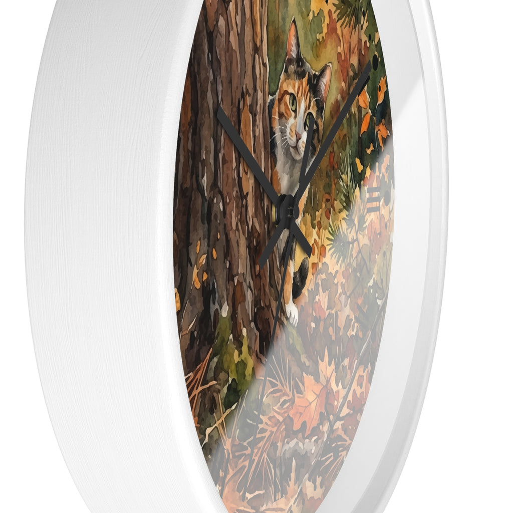 Round wall clock with a white frame and a printed autumn forest scene featuring a calico cat near a tree trunk, shown against a white background.