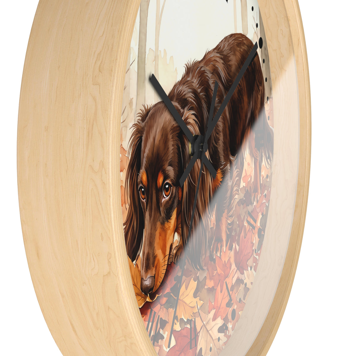 Round wall clock with a light natural wood frame and a printed center illustration of a brown dachshund walking through autumn leaves, shown against a plain white background.