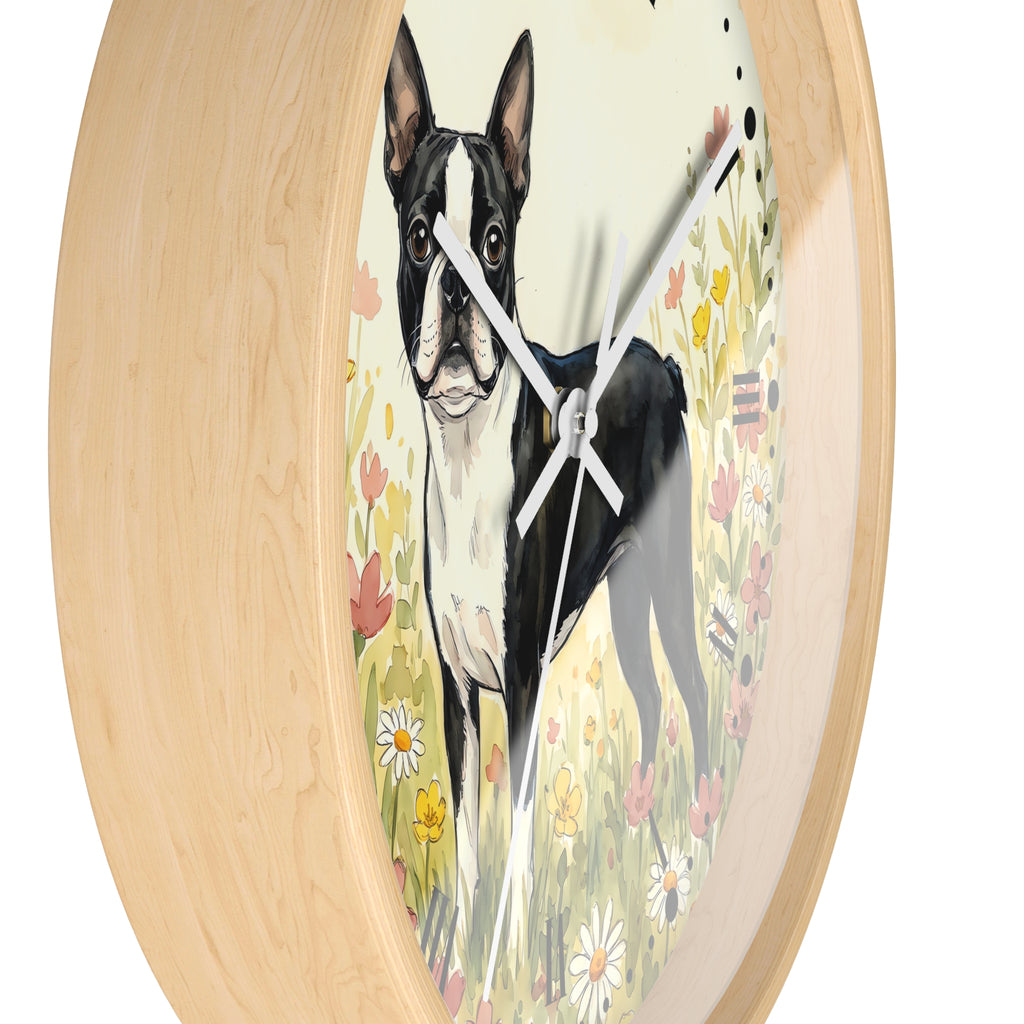 Round wall clock with a light natural wood frame and a printed face showing a black-and-white Boston Terrier standing in a flower field. The clock is photographed against a plain white background.