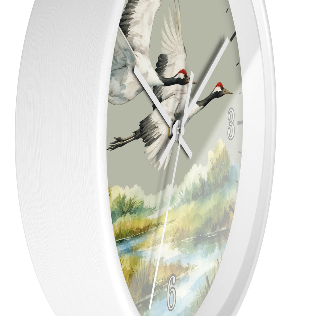 A white round wall clock with a detailed watercolor-style nature print featuring two flying cranes over a river landscape on the dial.