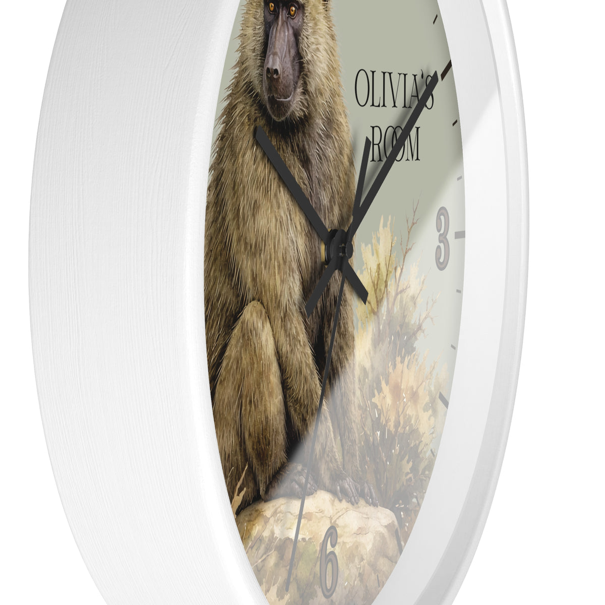 A white round wall clock featuring a printed illustration of a baboon on the face, with black hands, partial black numerals, and the text 'OLIVIA'S ROOM' near the top right.