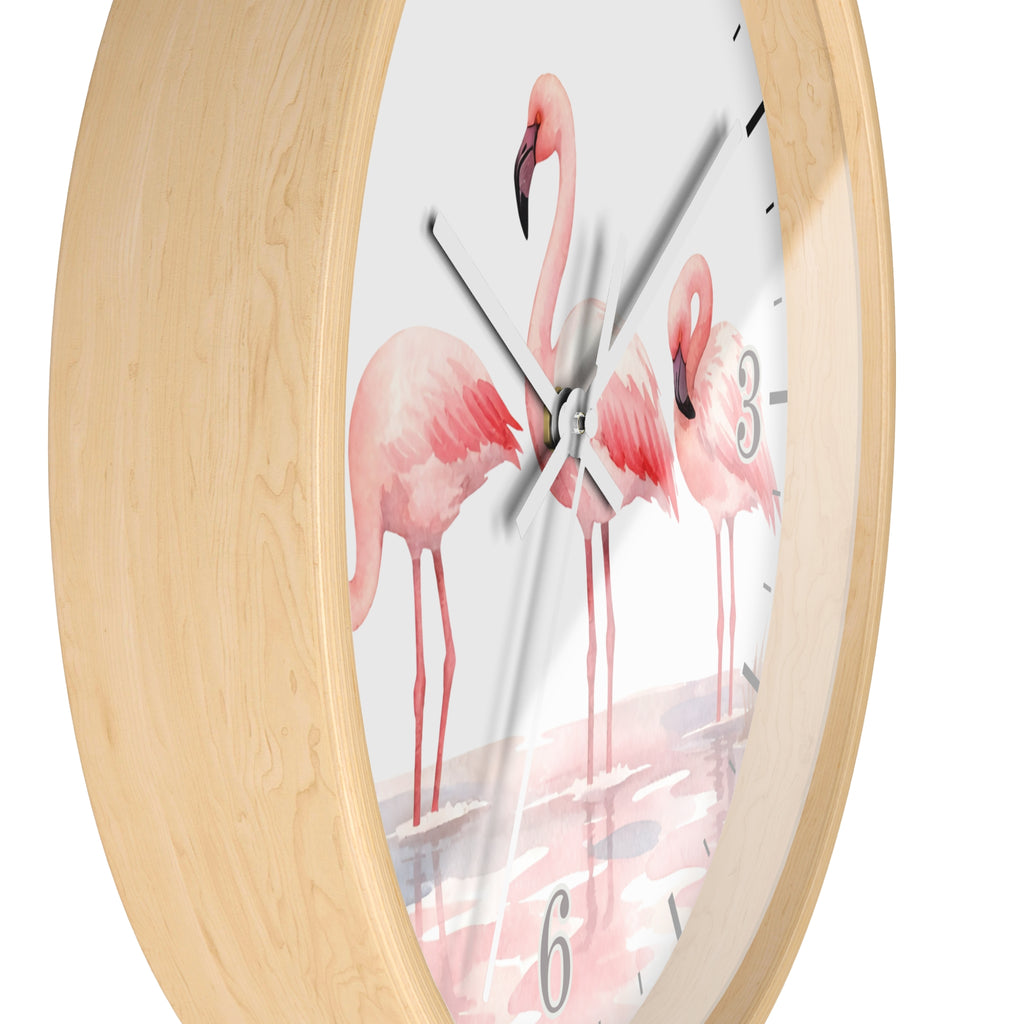 Round wall clock with a light natural wood frame and a white dial printed with pink flamingo illustrations and black numerals, shown against a white background.
