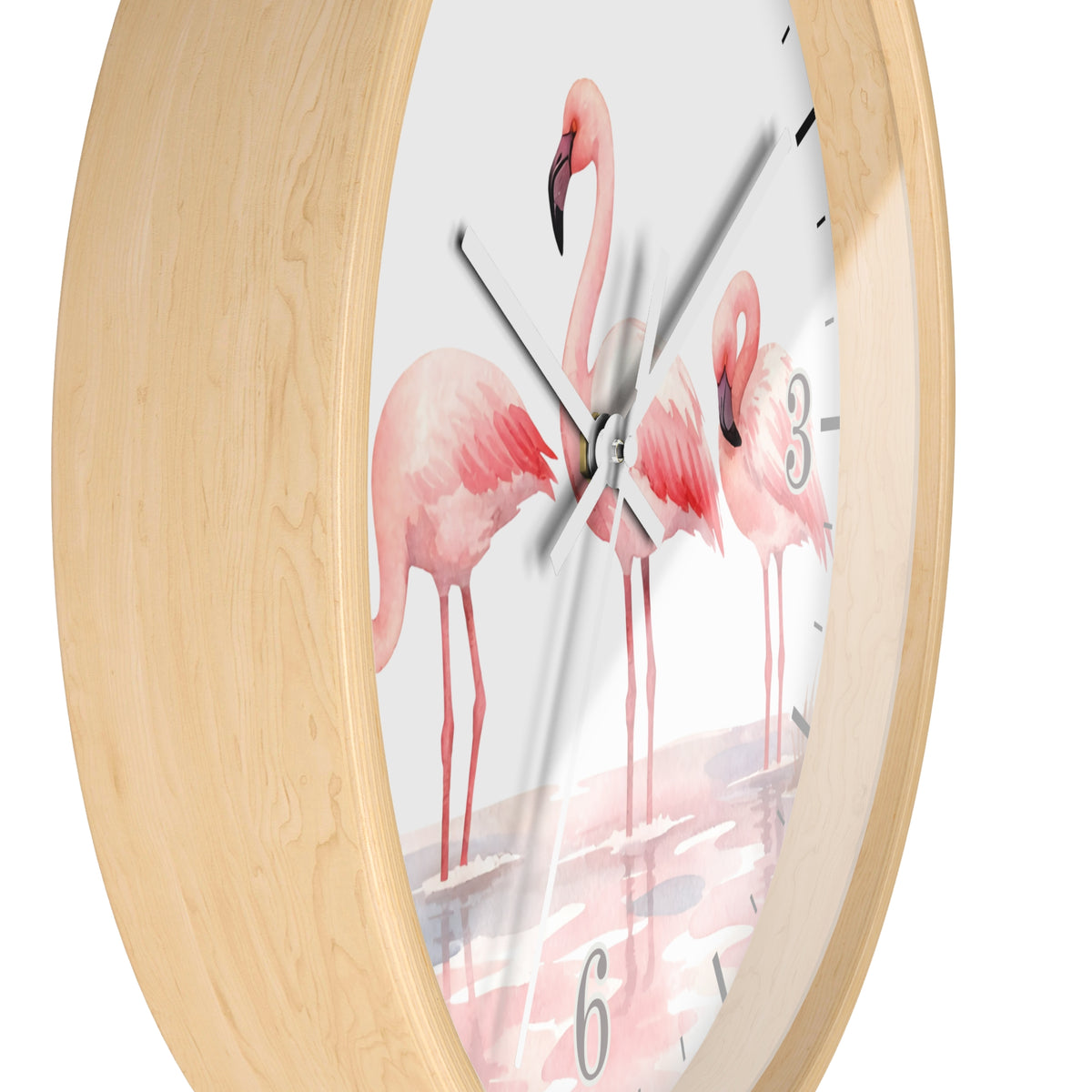 Round wall clock with a light natural wood frame and a white dial printed with pink flamingo illustrations and black numerals, shown against a white background.