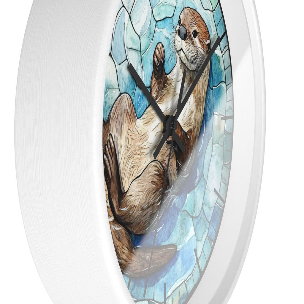 Round wall clock with a white frame and a printed illustration of an otter lying on a blue mosaic-style background, shown against a plain white backdrop.