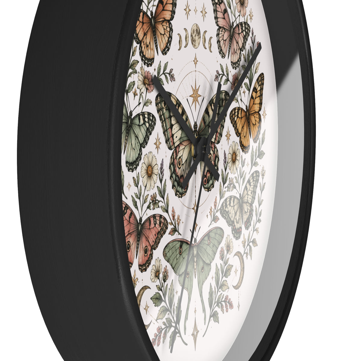 A close-up of a round wall clock with a black frame and a white dial decorated with vintage-style butterflies, floral illustrations, and celestial motifs.