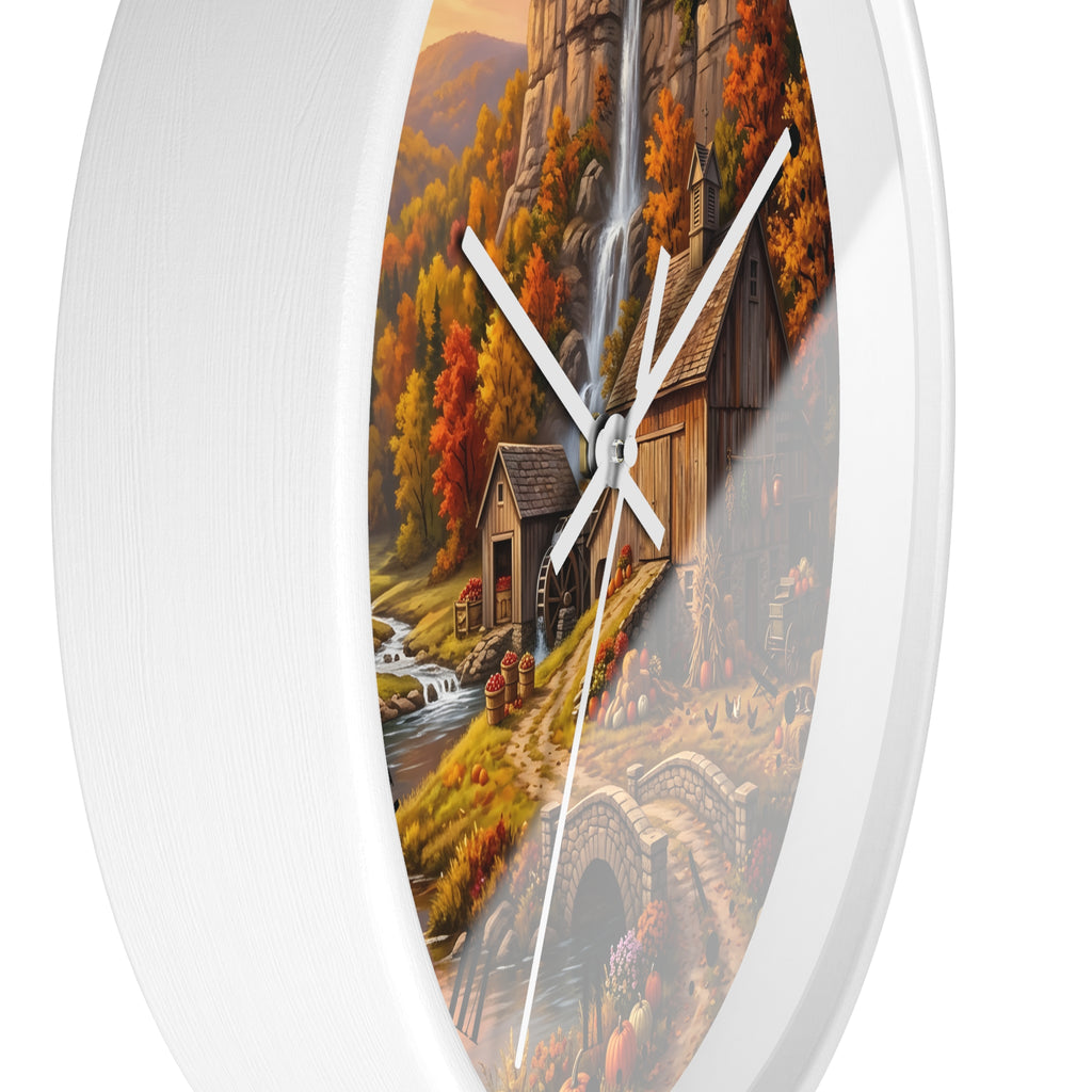 Round wall clock with a white frame and a printed autumn landscape design featuring a rustic cabin, waterfall, stream, and stone bridge.