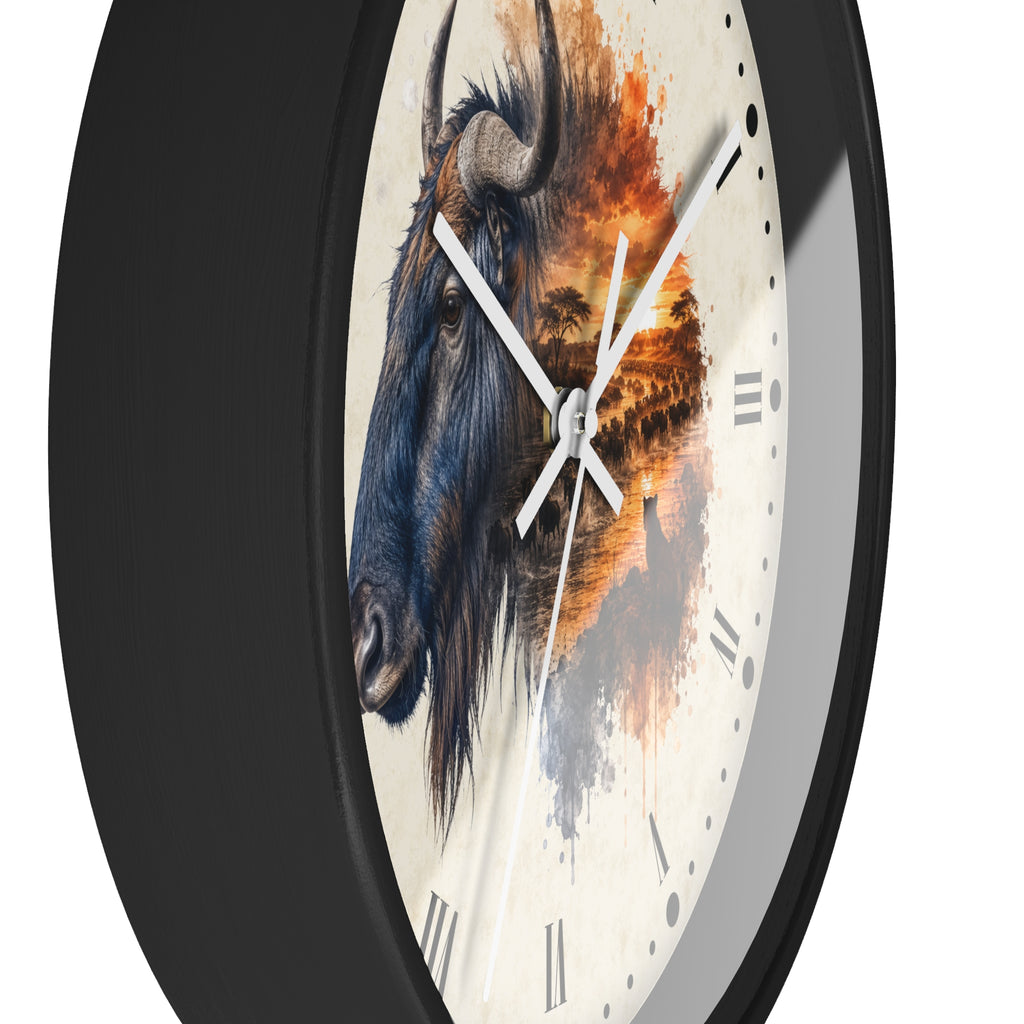 A close-up of a round wall clock with a black frame and a cream-colored face featuring a painted wildebeest and warm-toned landscape artwork, shown against a white background.