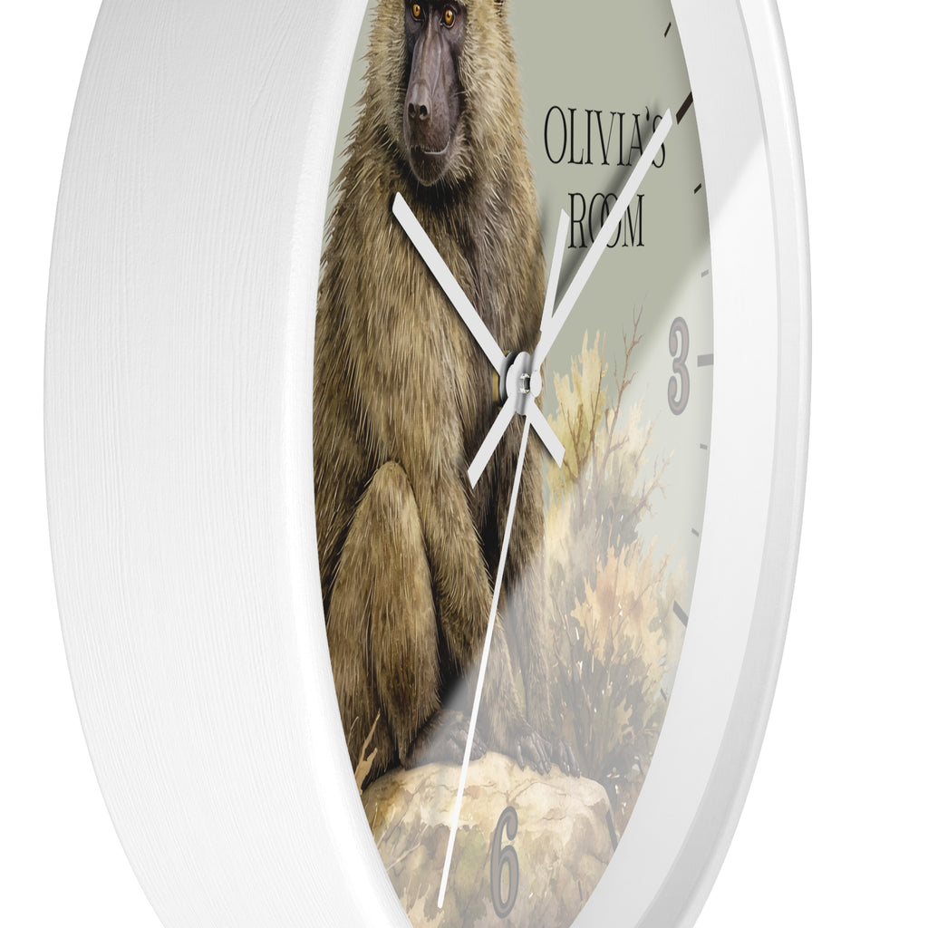 Oval wall clock with a white frame and a printed face showing a baboon illustration, the text 'OLIVIA'S ROOM,' and gray numerals.