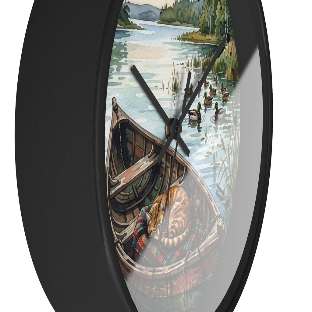Round wall clock with a black frame and a printed scenic dial showing a rowboat on a lake with ducks and trees, photographed against a white background.