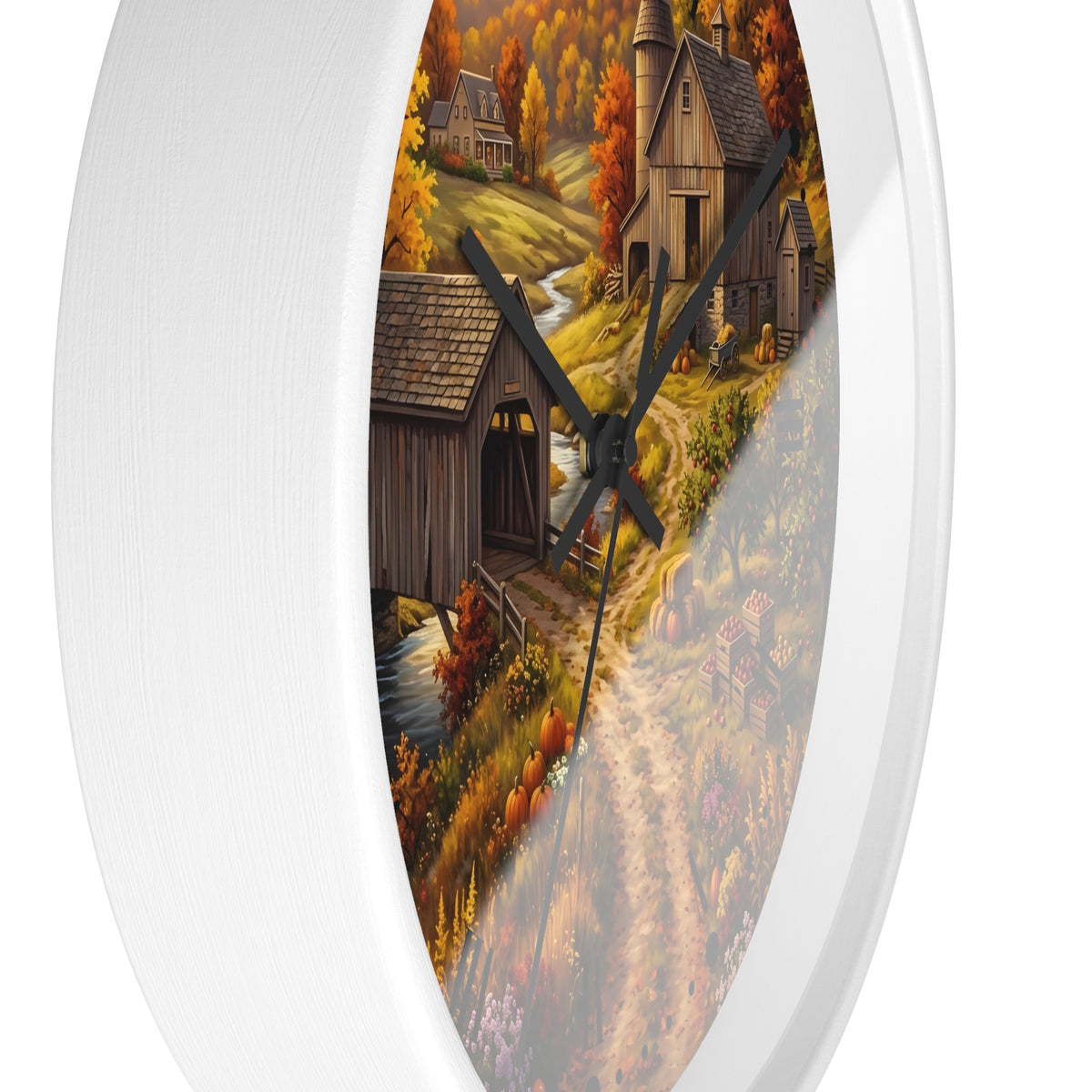 Round wall clock with a white frame and a printed autumn landscape design featuring a covered bridge, rustic cabin, trees, and a winding path. The clock face is partially obscured by a diagonal translucent overlay.