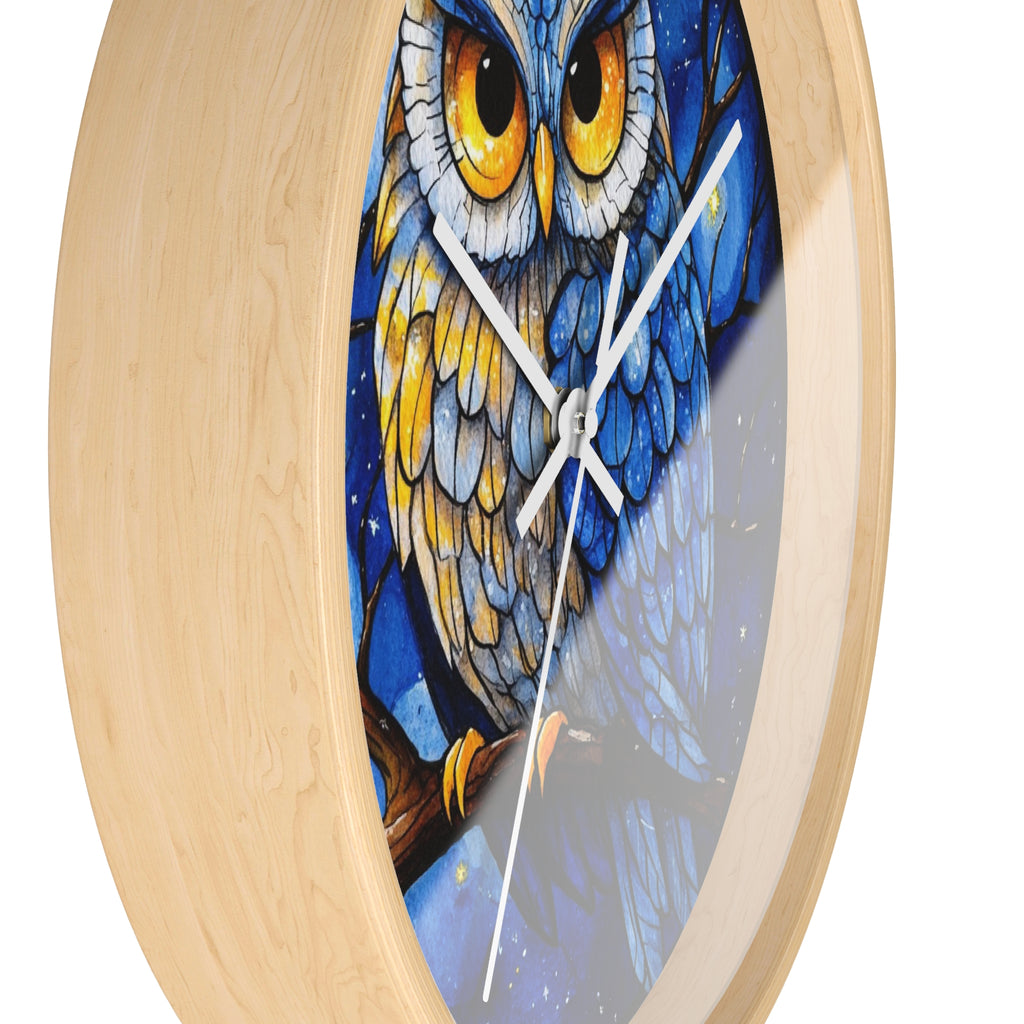 Round wall clock with a light natural wood frame and a printed owl illustration on the face. The owl artwork features blue, gray, yellow, and white tones, with white clock hands and no visible numerals.