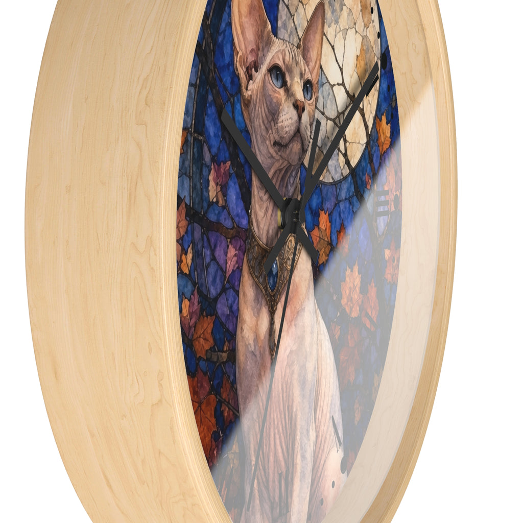 Round wall clock with a light natural wood frame and a stained-glass-style artwork of a hairless cat in front of blue and orange autumn leaves.