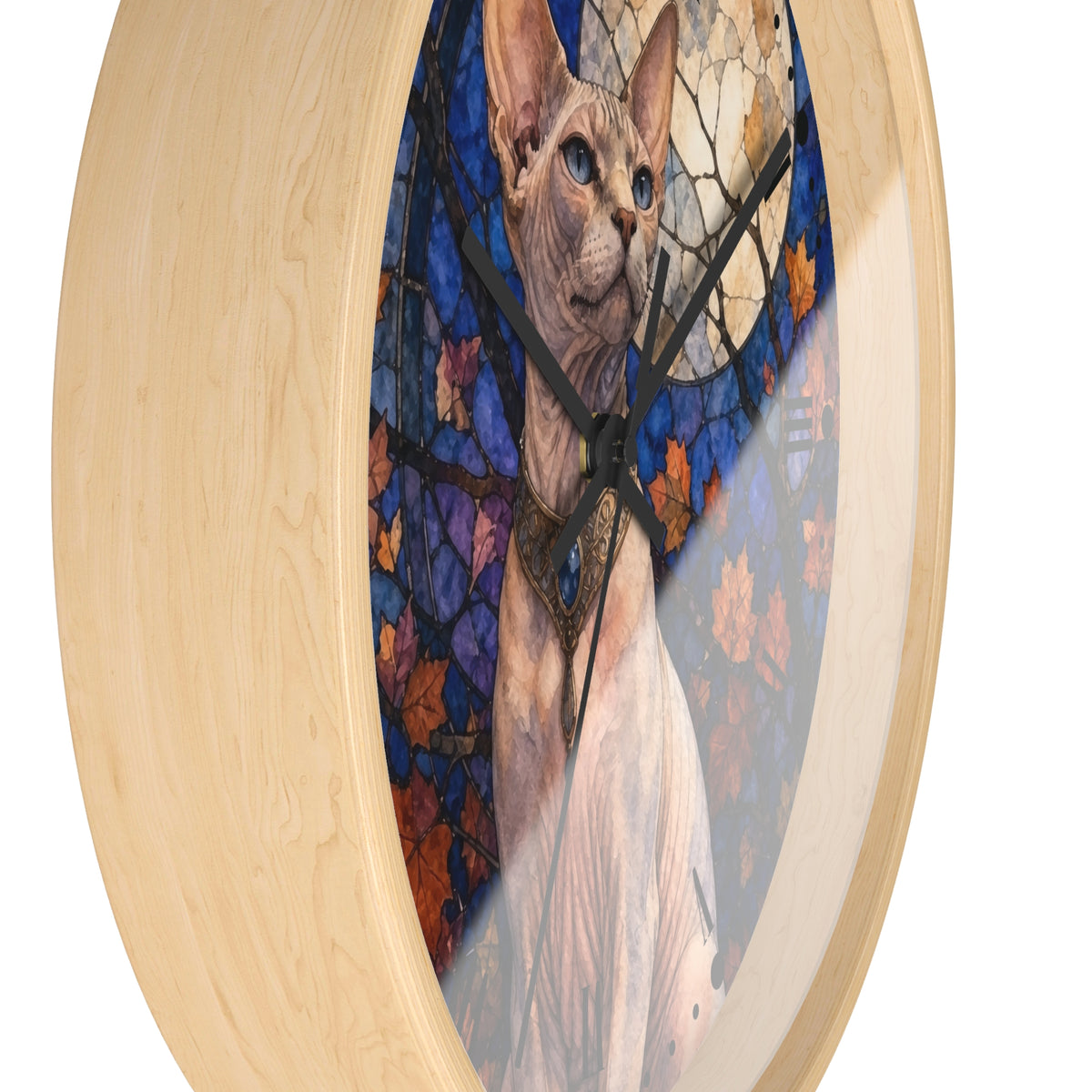 Round wall clock with a light natural wood frame and a stained-glass-style artwork of a hairless cat in front of blue and orange autumn leaves.