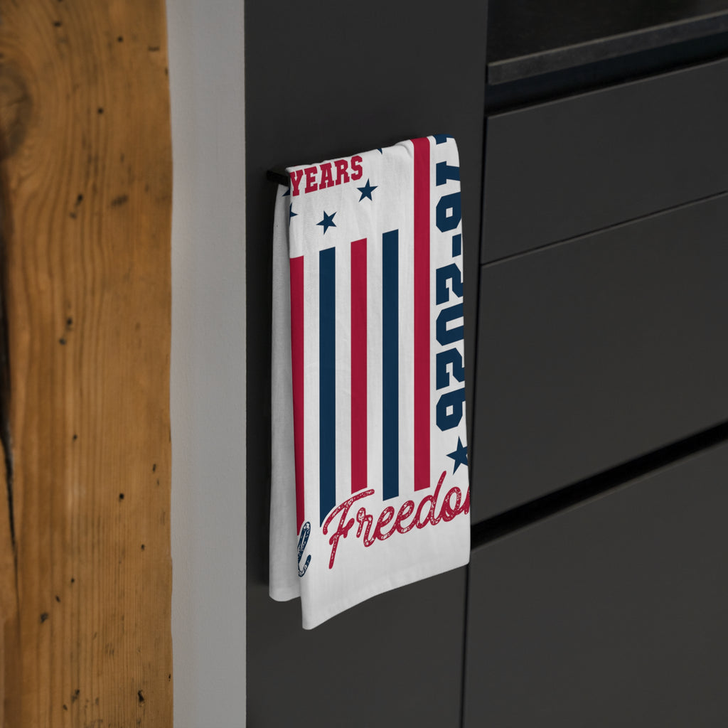 Tea towel with red, white, and blue design hanging on a black surface.