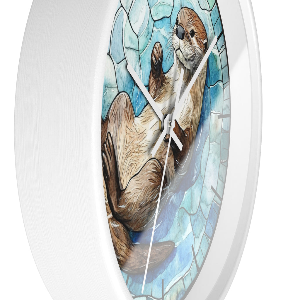 An oval wall clock with a white frame and a printed illustration of an otter on a blue mosaic-style background. The clock is shown at an angle against a plain white background.