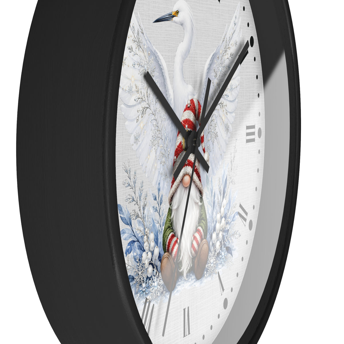 A close-up of a round wall clock with a black frame and a white face featuring a winter bird and gnome illustration, photographed against a light gray background.