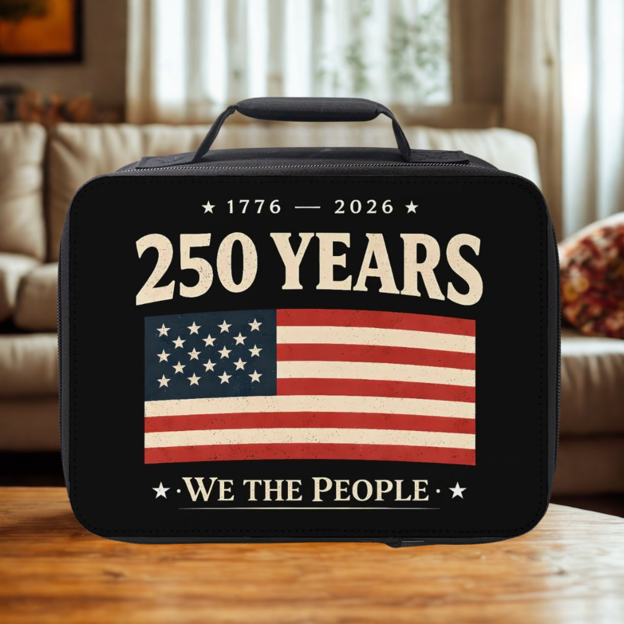 Black lunch box with American flag and '250 Years We The People' text on a wooden coffee table in a cozy living room.
