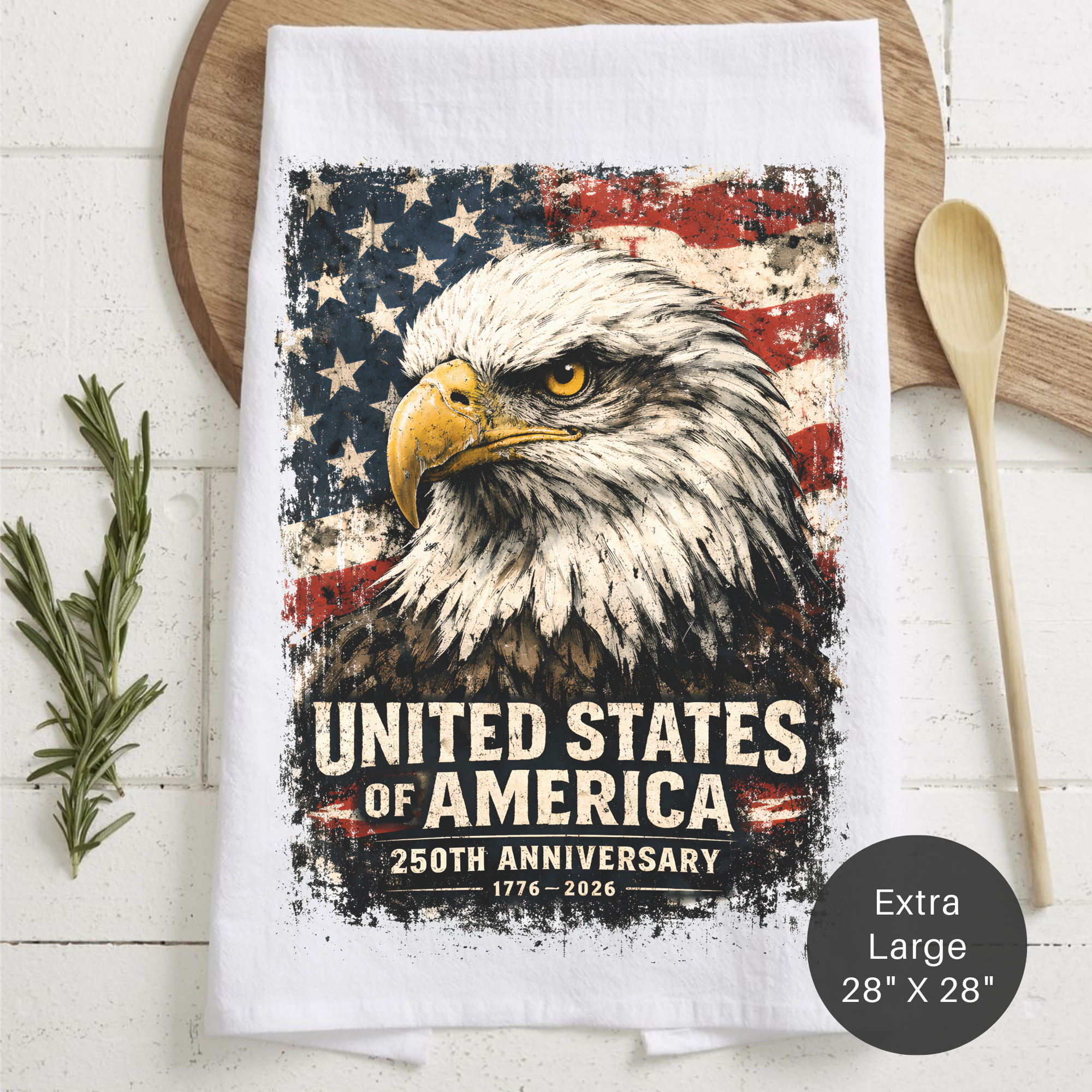Tea towel with American flag and bald eagle design on a wooden board.