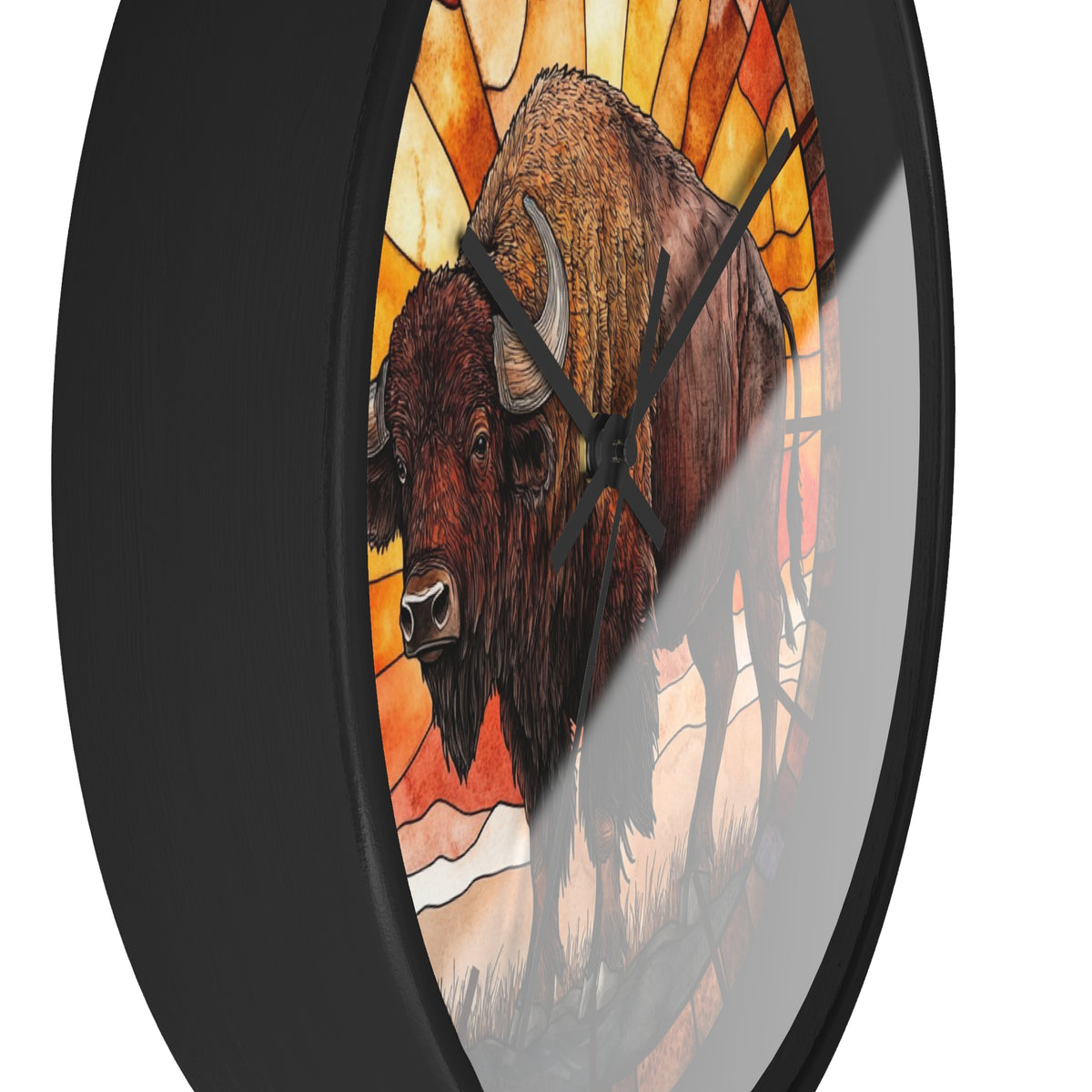 Round wall clock with a black frame and a stained-glass-style illustration of two bison in warm orange, yellow, and brown tones. The clock is shown at an angle against a plain white background.