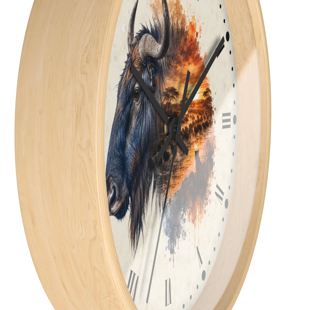 Round wall clock with a light natural wood frame and a printed face featuring a detailed blue-gray Wildebeest portrait blending into an orange sunset landscape. Black clock hands and Roman numerals are visible against a plain white background.