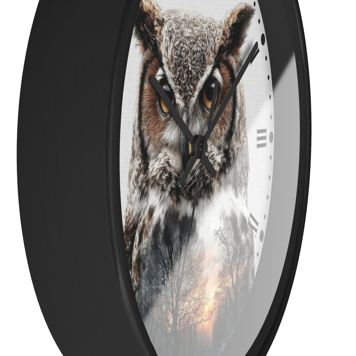 A close-up of a round wall clock with a black frame and a printed owl face on the dial. The clock shows black hands, partial Roman numerals, and a white lower section with a faint forest scene.