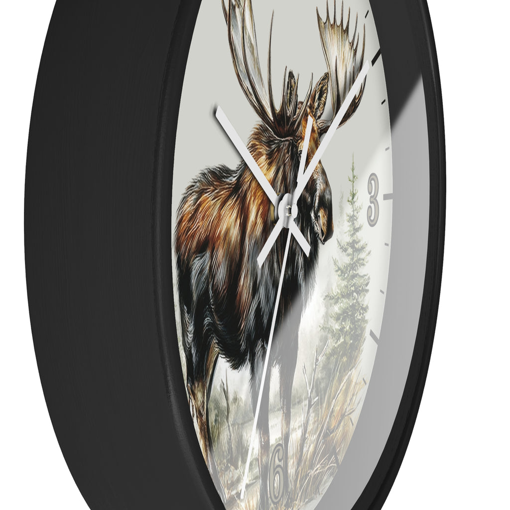 A round wall clock with a black frame and a printed face showing a moose in a forest, photographed against a plain white background.