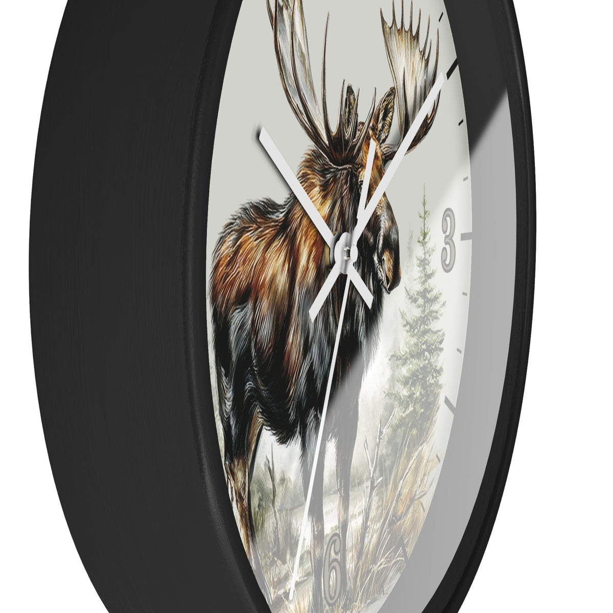 A round wall clock with a black frame and a printed face showing a moose in a forest, photographed against a plain white background.