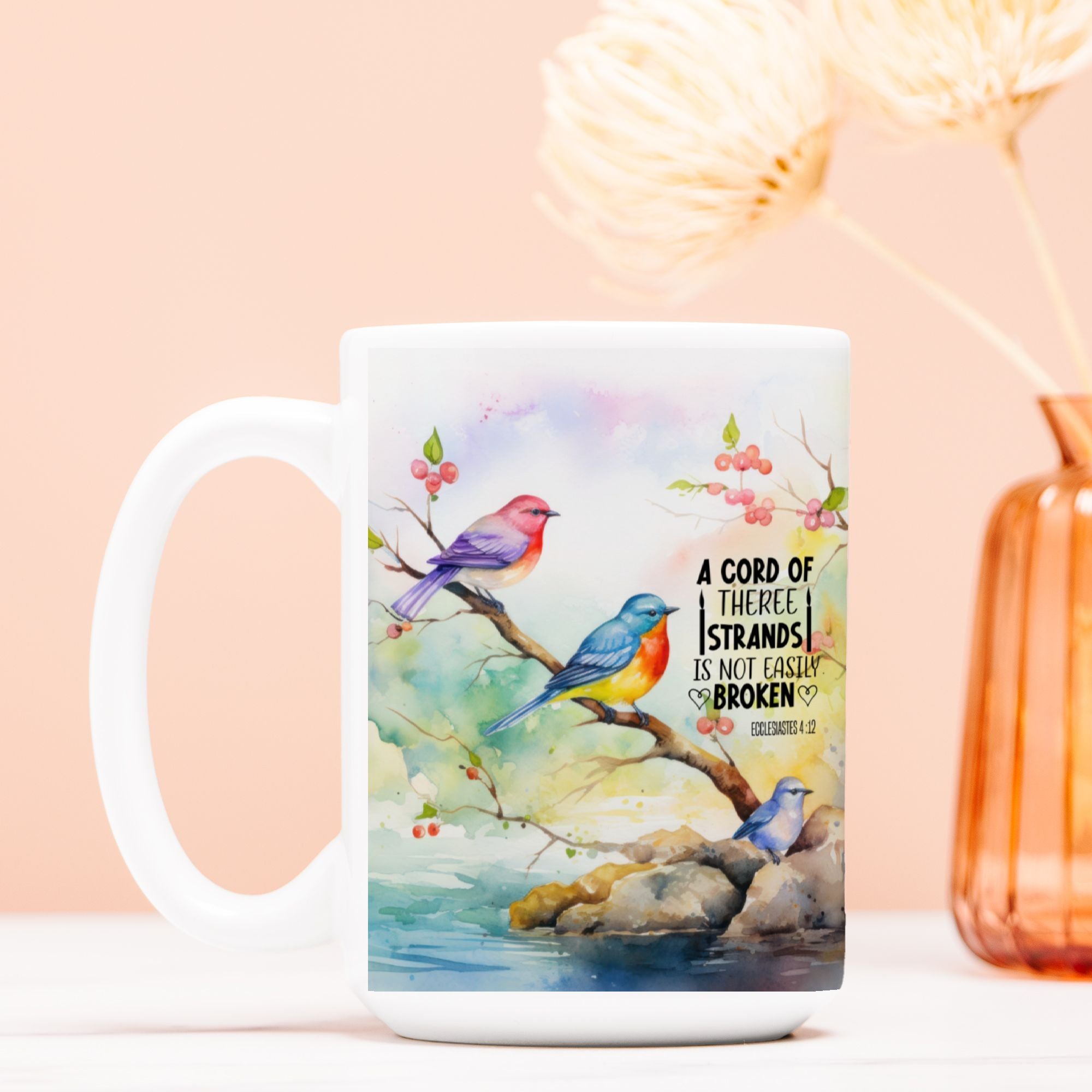 White mug with colorful bird design and text on a light pink background