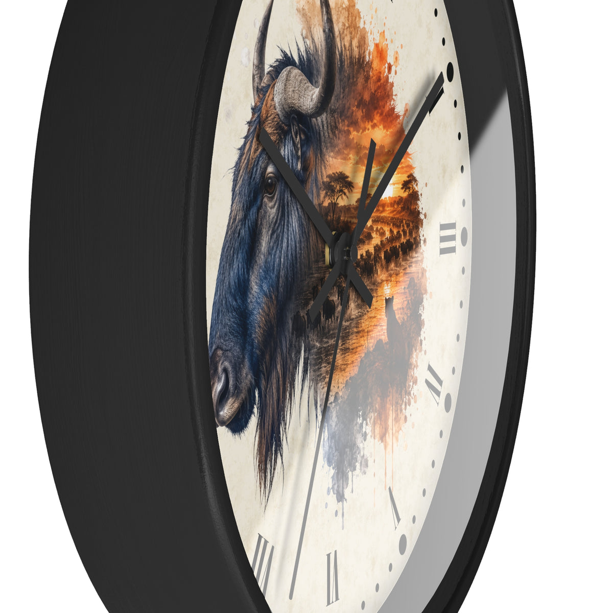 A round wall clock with a black frame and a white face featuring a painted blue-gray wildebeest on the left and an orange sunset landscape with a lioness in the grass on the right. The clock is shown at an angle against a plain white background.