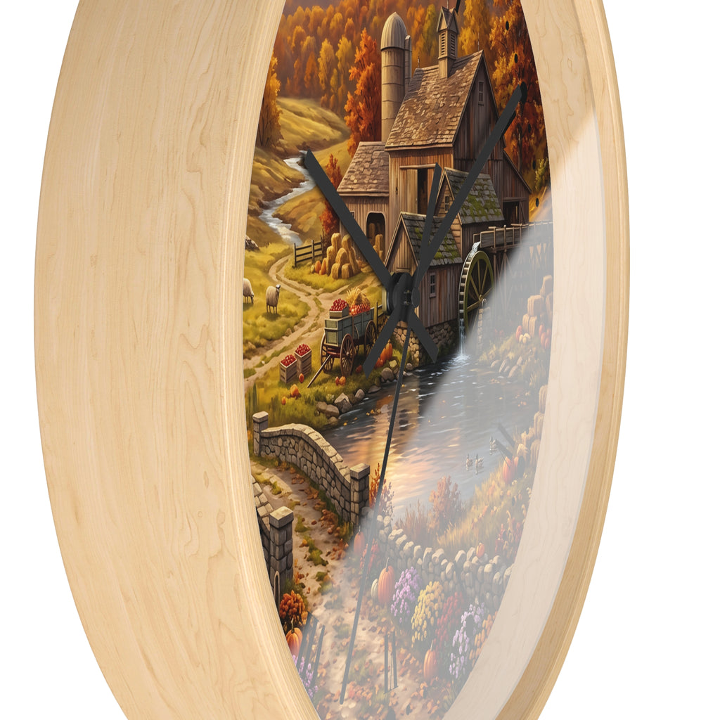 Round wall clock with a light natural wood frame and a printed scenic illustration of an autumn mill scene with a mill, water, crops, and a tractor, shown against a white background.