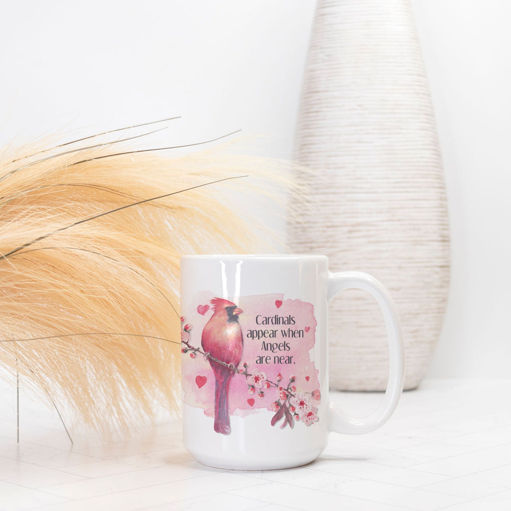 White mug with a pink cardinal design and text on a white background