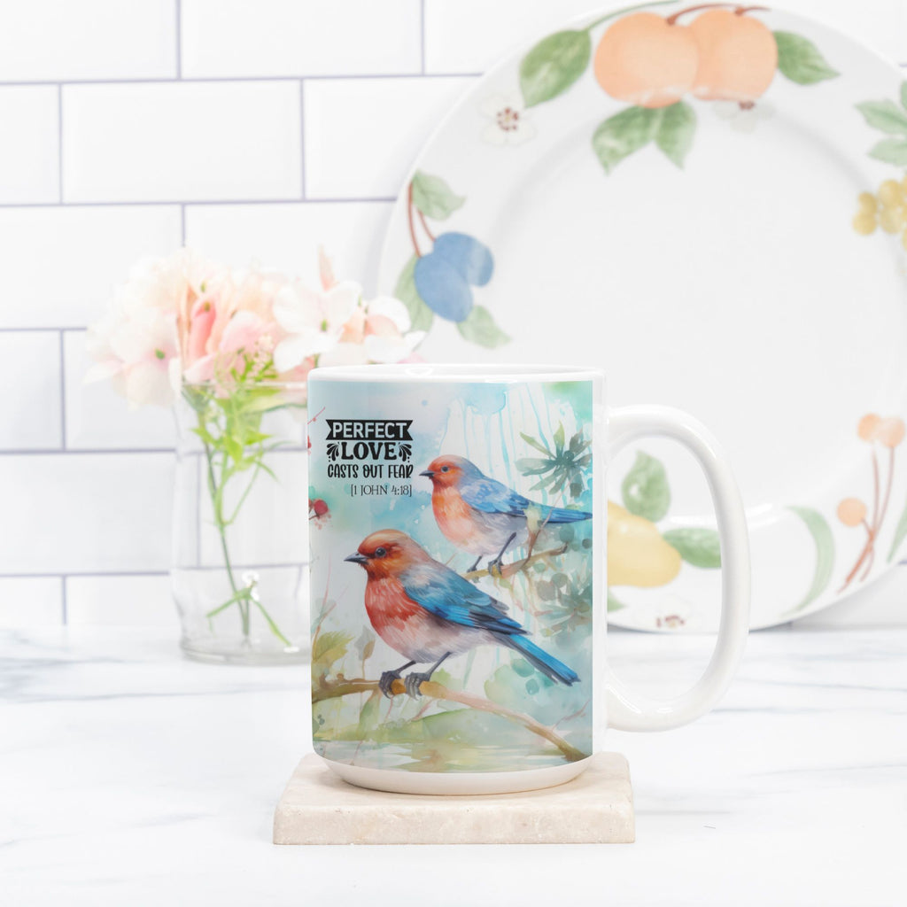 Mug with bird design on a white surface with a plate and flowers in the background