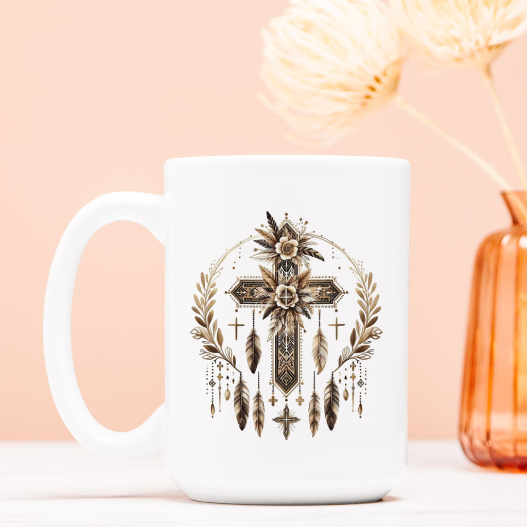 White mug with a decorative cross and feather design on a peach background